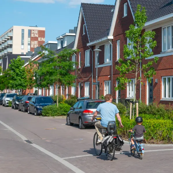 Vader die fiets met huizen op achtergrond