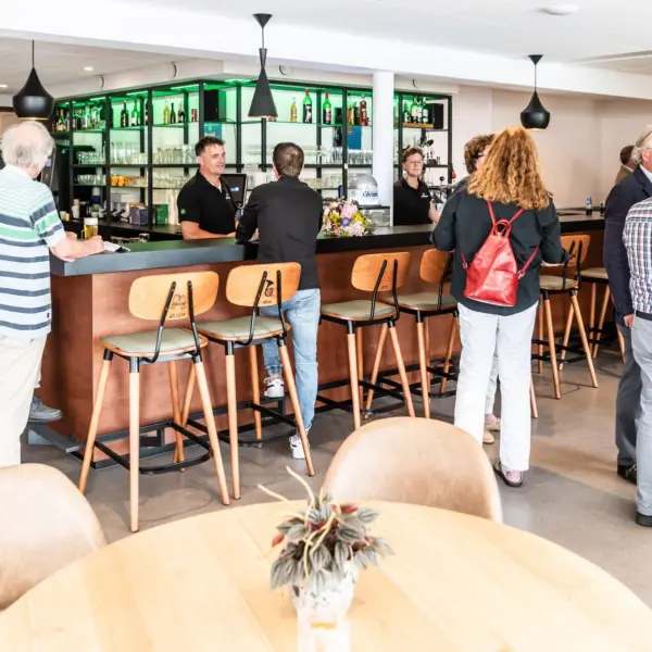 een aantal volwassen personen bij een bar van een woonzorginstelling