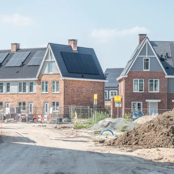 Nieuwbouwwoningen met zonnepanelen in aanbouw als voorbeeld van de versnelling van woningbouw in Nederland.