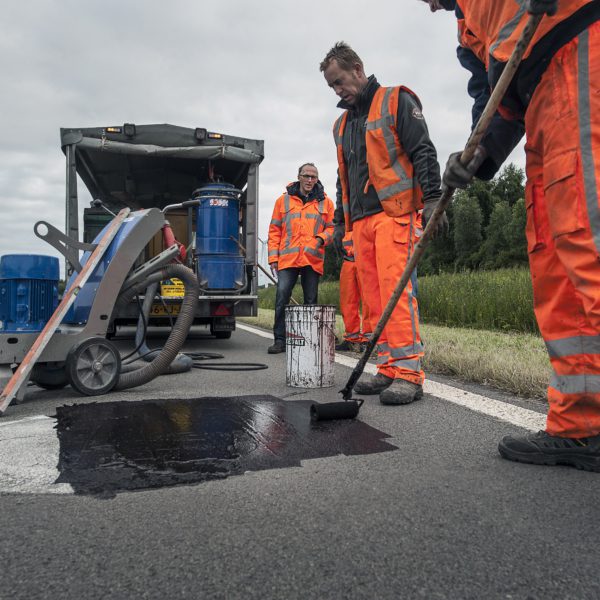 Mannen werken aan de weg