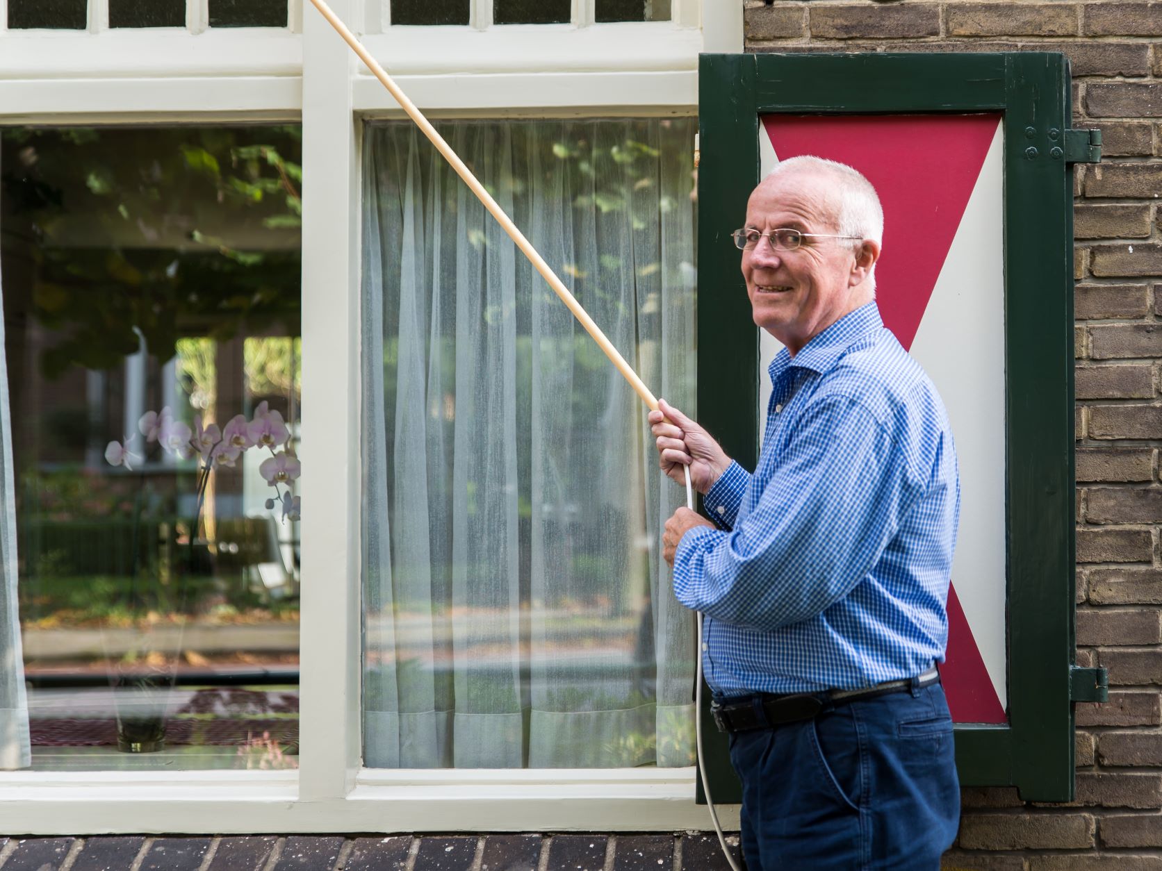 Oudere_man_voor_zijn_woning_