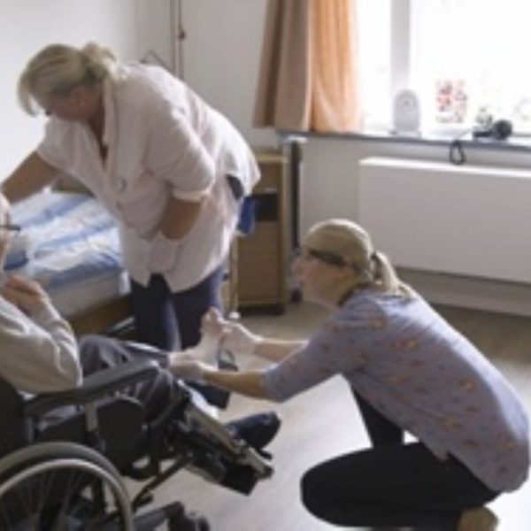 Man in rolstoel wordt verpleegd