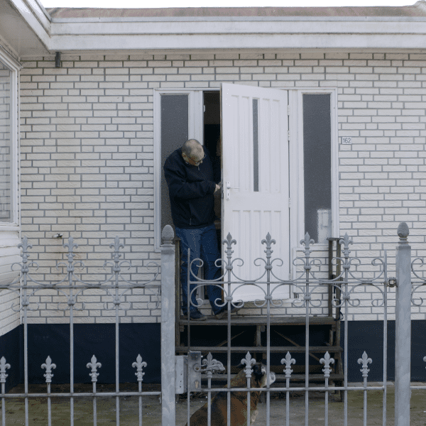 Woonwagenbewoner die de deur van zijn woonwagen repareert