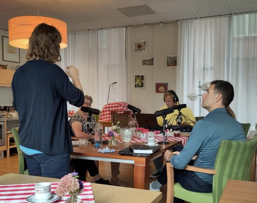 Mensen aan tafel nemen een podcast op