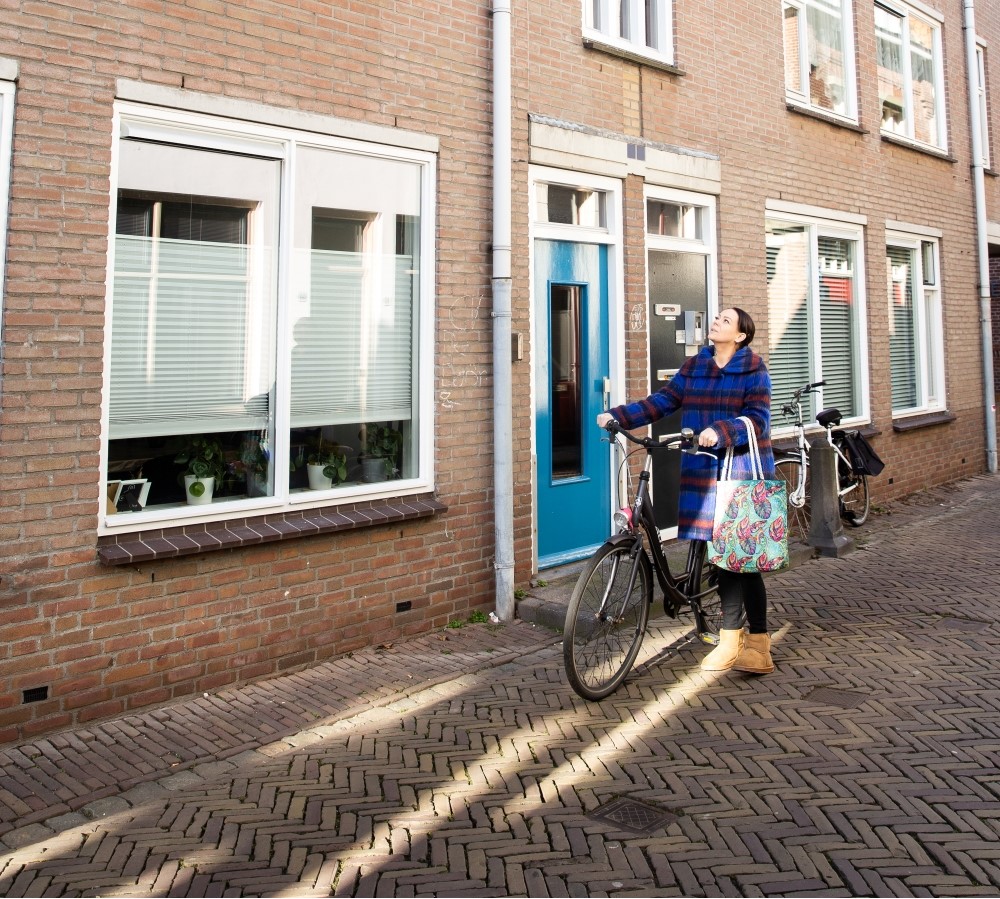 Dame op fiets voor huis Gorinchem