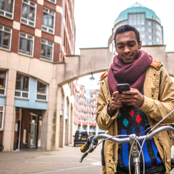 Een man met een telefoon in zijn handen op de fiets.